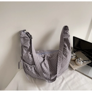 Detail of purple plaid canvas tote bag with drawstring pocket and adjustable strap