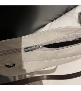 Close-up of smooth silver zipper and interior lining of this cream canvas tote bag