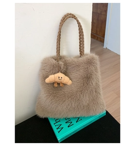 Detail of plush brown faux fur tote bag with woven handle and cute smiley face charm