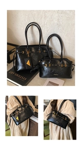 Detail view of glossy black pleated tote bags with gold rings and polished metal buckles