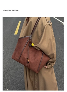 Detail of vintage brown suede tote bag with long tassels and wooden beads pendant