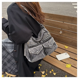 Détail du sac fourre-tout en denim gris fumé avec poches et fermetures éclair