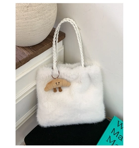 Detail of white faux fur tote bag with braided handle and croissant plush charm