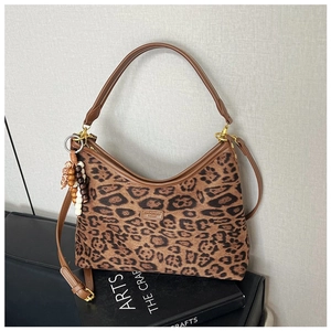 Details der Handtasche mit Leopardenmuster, braunem Lederbesatz und Perlenquaste