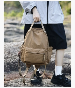 Detail of khaki nylon backpack with water-resistant fabric in an outdoor setting