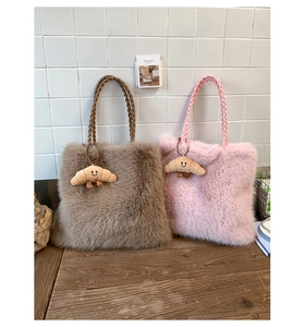 Detail of plush tote bag texture with woven handle and smiling croissant pendant accessory