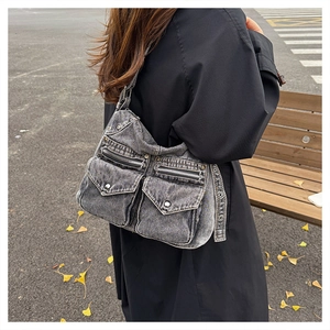 Vue extérieure d'un grand sac cabas vintage en denim gris avec poches et clous en métal