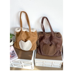 Detail of faux shearling trim and heart pattern on large faux suede tote bags