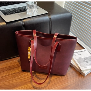 Détail du grand sac cabas bordeaux en toile avec anses en cuir et perles en bois