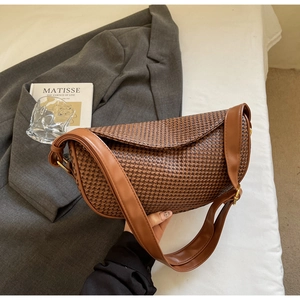 Detail of the brown woven texture and PU leather flap on the crossbody dumpling bag