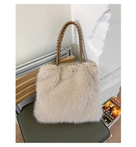 Detailed close-up of beige faux fur tote bag featuring woven brown leather handles