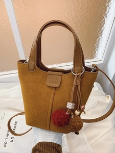 Secchiello in pelle scamosciata marrone con manico, tracolla e ciondolo a pompon decorativo