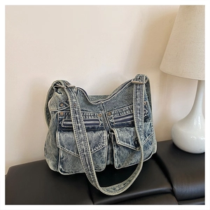 Détail du sac fourre-tout en denim bleu délavé avec poches multiples et boucles métal