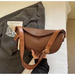 Close-up of brown woven dumpling bag featuring wooden beads and gold-tone hardware
