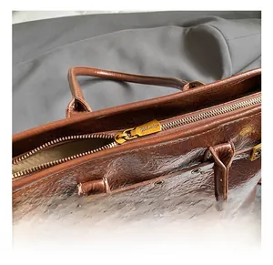 Detail of vintage dark brown waxed leather tote bag with antique bronze zipper hardware
