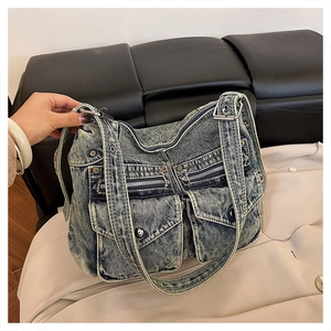 Détail du sac fourre-tout en denim délavé bleu avec plusieurs poches et quincaillerie Y2K