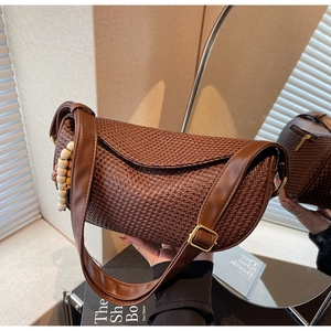 Detail of brown woven hobo bag with wooden beads and gold metallic buckle accents