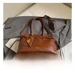 Macro detail of brown oil-wax leather texture and metal logo on vintage tote bag