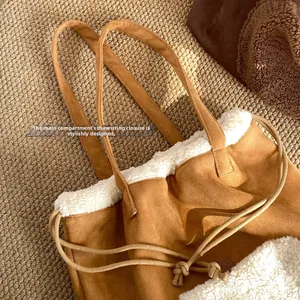 Detail of brown suede tote bag featuring plush faux fur trim and secure drawstring closure