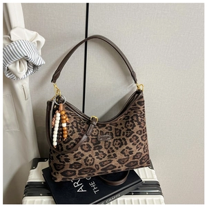 Nahaufnahme der Schultertasche mit Leopardenmuster, braunem Gurt und Perlenanhänger