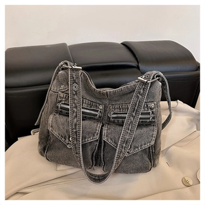 Gros plan sur un sac cabas en jean gris rétro avec poches et boucles en métal argenté