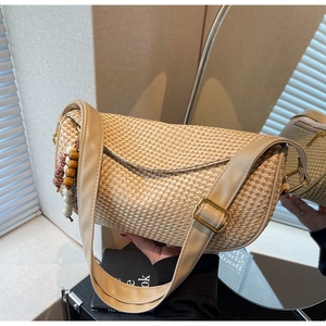 Detail of woven straw dumpling bag with wooden beads and beige faux leather strap