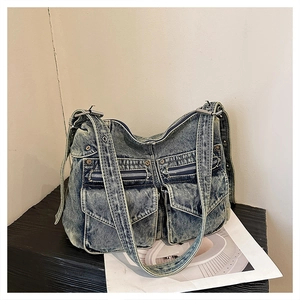 Détail du sac cabas en denim bleu vintage avec plusieurs poches et boucles en métal