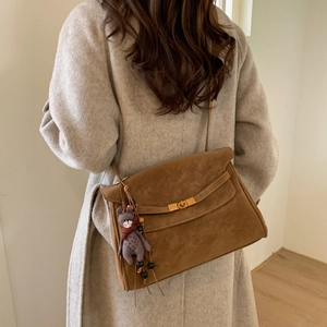 Brown suede crossbody bag with gold twist lock and a cute purple plush bear charm