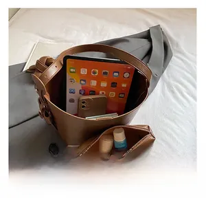 Detail view of brown leather bucket bag interior capacity with matching small makeup pouch