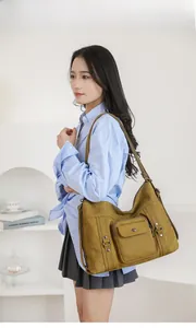 Detailed view of ginger canvas hobo bag with multi-pocket design on a fashion model