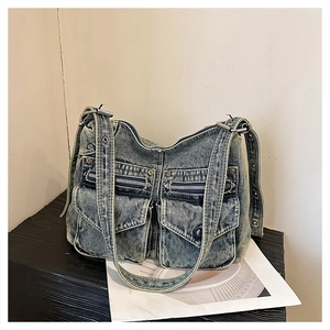 Détail du sac fourre-tout en jean vintage montrant poches cargo et tissu délavé