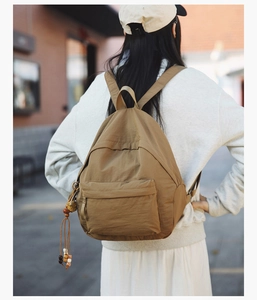 Outdoor view of a lightweight khaki nylon backpack with large capacity and ethnic charm