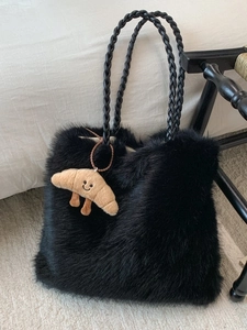 Fuzzy black plush tote bag with woven handles and a cute croissant plush charm accessory