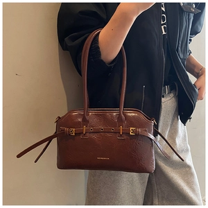 Close-up of vintage brown tote bag featuring oily wax leather texture and gold buckle