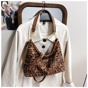 Detail der Schultertasche aus Leoparden-Canvas mit braunen Lederriemen und Goldbeschlägen