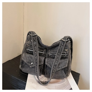 Gros plan détaillé du sac hobo en jean délavé gris avec poches cargo et zips argentés