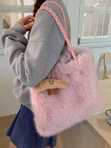 Pink fluffy faux fur tote bag with croissant charm shown on a female model shoulder