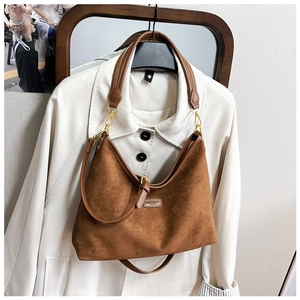 Detail einer braunen Vintage-Wildleder-Hobo-Bag mit goldenen Elementen am Mantel