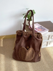Brown suede tote bag featuring a large plush heart patch and stylish fuzzy trim details