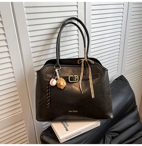 Detail view of large faux suede tote bag with metal buckles and decorative scarf