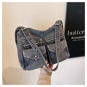 Gros plan du sac cabas en denim gris vintage avec poches multiples et détails zippés