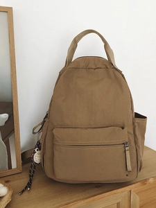 Minimalist khaki nylon backpack for students with zipper pocket and owl pendant accessory