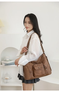 Close-up of retro brown tote bag with metal rivet details and magnetic flap pocket