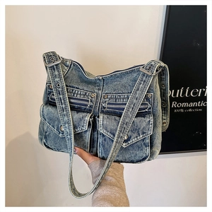 Détail du sac fourre-tout en denim bleu vintage avec poches cargo et zips métalliques