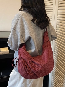 Red checkered large crescent crossbody bag with adjustable drawstring on model