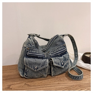 Détail du sac cabas vintage en denim bleu avec plusieurs poches et rivets en métal