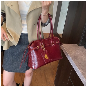 Detailed close-up of dark red tote bag with shiny crinkled leather and gold hardware
