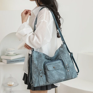 Detailed view of a vintage dark blue tote bag with metallic rivet decorative straps