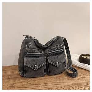 Détail du sac en jean gris montrant le design multipoches et la bandoulière à œillets