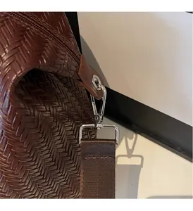 Détail du sac Boston marron tissé avec anneaux en D argentés et bandoulière en tissu